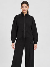 Modella indossa felpa full zip nera Follower SRL con coulisse in vita e collo alto, abbinata a pantaloni neri