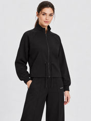 Modella indossa felpa full zip nera Follower SRL con collo alto e coulisse in vita, stile sportivo ed elegante