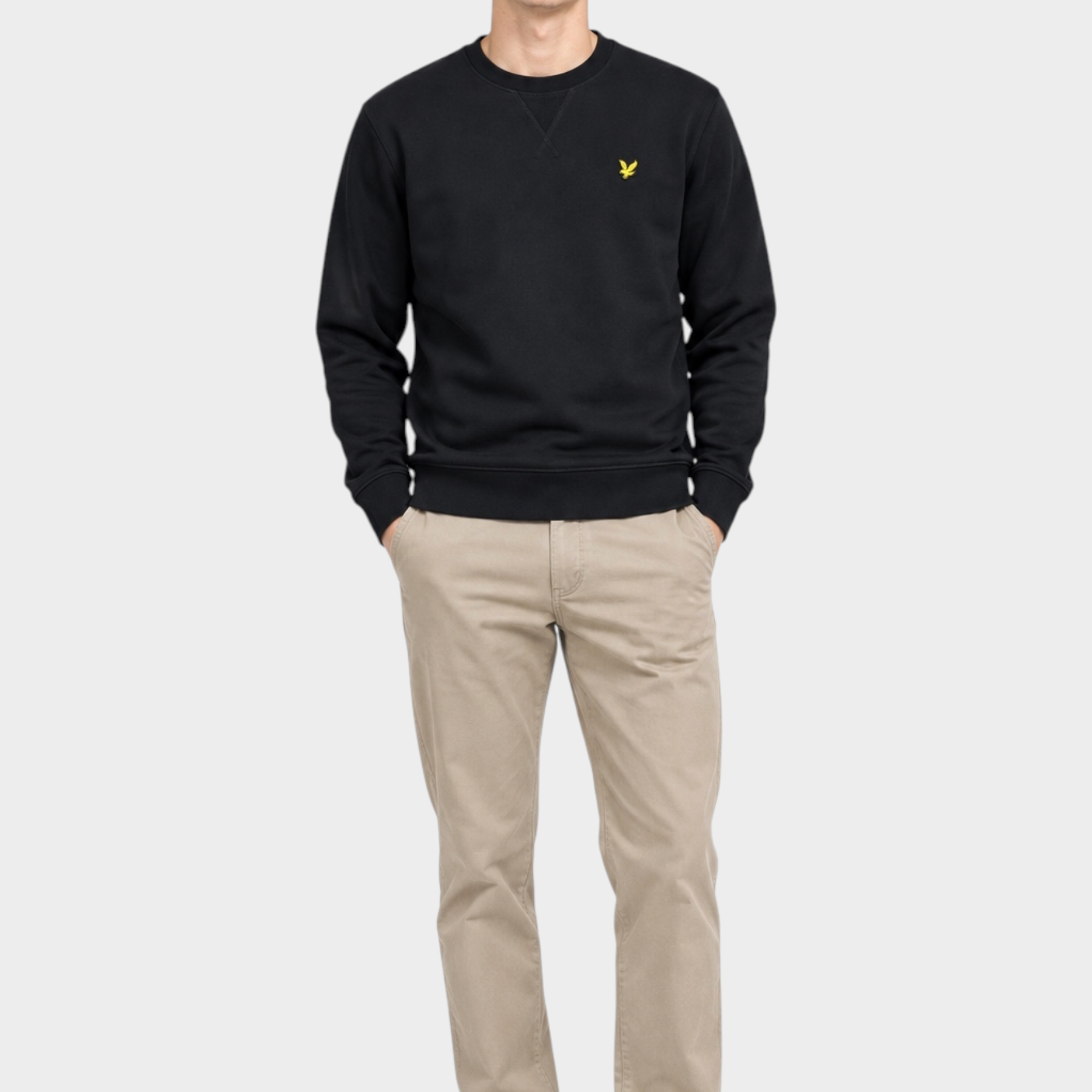Modello indossa felpa girocollo nera in cotone Lyle & Scott con logo giallo, venduta da Follower SRL