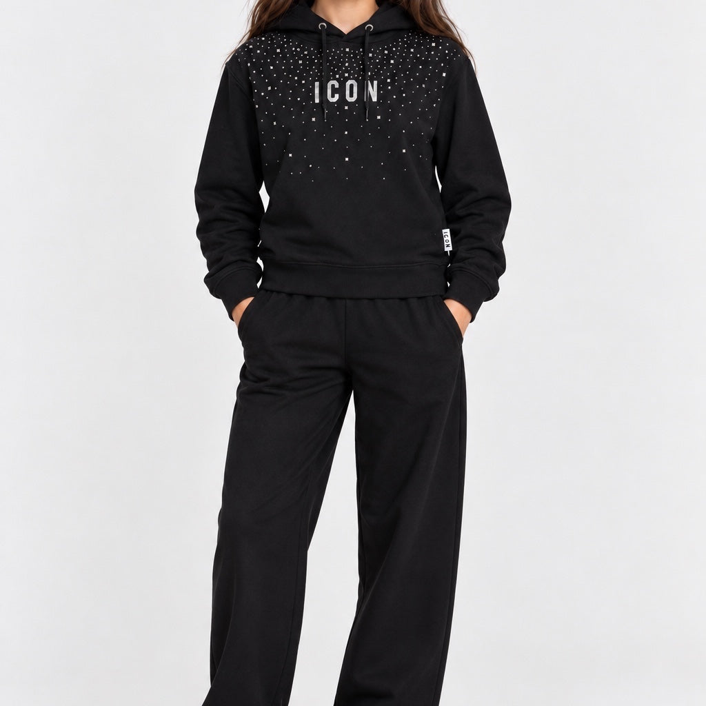Ragazza indossa felpa nera Follower SRL con cappuccio, scritta ICON e decorazioni di strass, abbinata a pantaloni