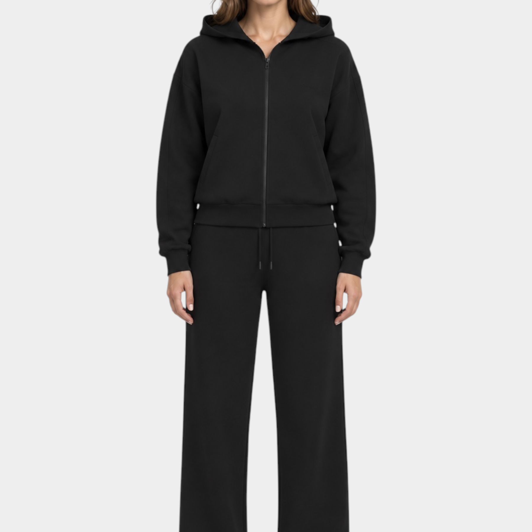 Modella indossa felpa con cappuccio full zip nera GUESS e pantaloni coordinati Follower SRL