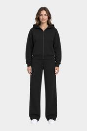 Modella indossa felpa con cappuccio full zip nera GUESS e pantaloni coordinati Follower SRL