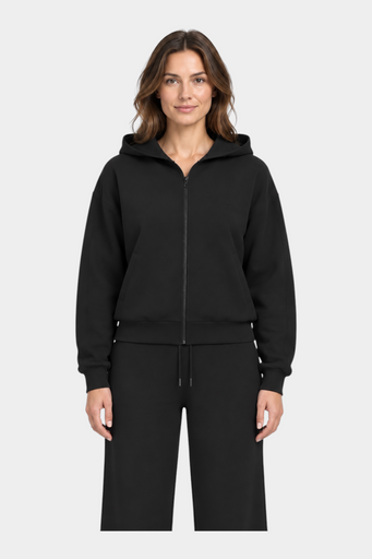 Modella indossa una felpa con cappuccio e zip intera nera GUESS, dal design minimalista e vestibilità confortevole.