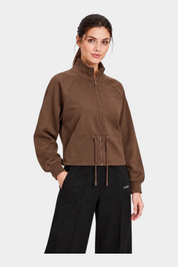 Modella indossa una felpa full zip marrone GUESS con coulisse in vita, proposta da Follower SRL