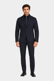 Modello indossa giacca blu GUESS con zip interna e chiusura a bottoni, abbinata a pantaloni sartoriali Follower SRL
