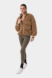 Modella indossa giacca bomber in finta pelliccia di montone marrone Follower SRL con chiusura zip e tasche frontali
