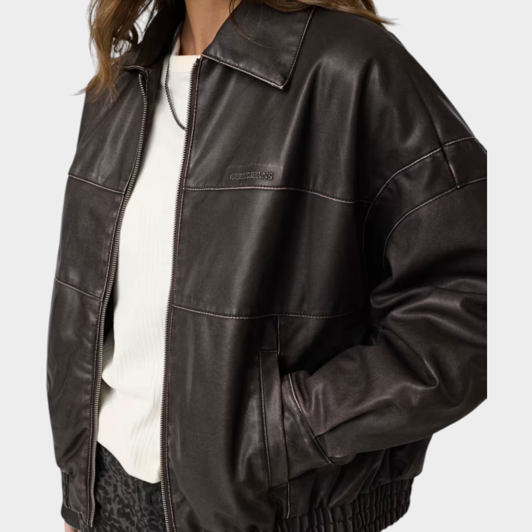 Giacca bomber Follower SRL in similpelle marrone con zip frontale e cuciture a vista indossata da una modella