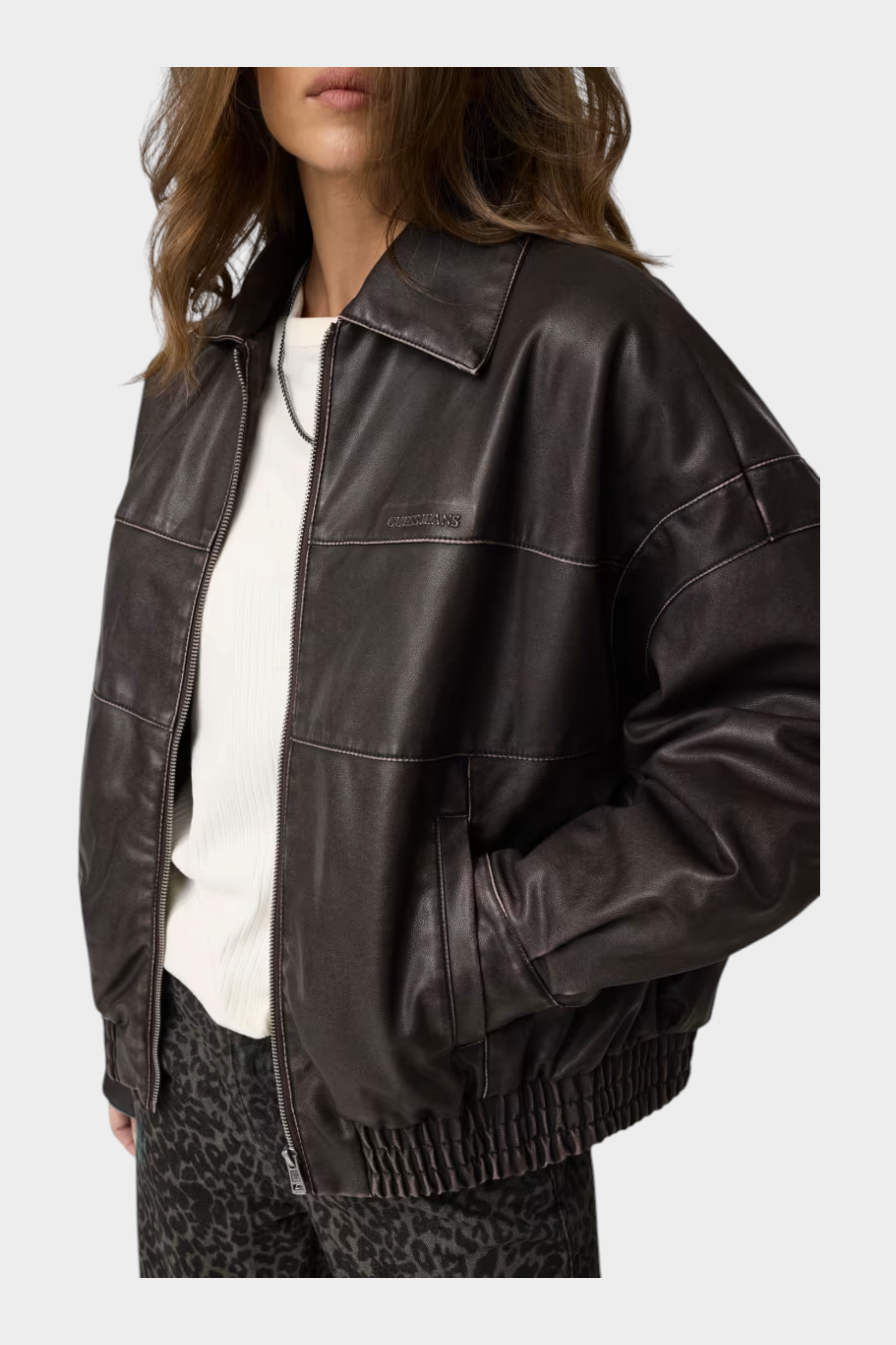 Giacca bomber Follower SRL in similpelle marrone con zip frontale e cuciture a vista indossata da una modella
