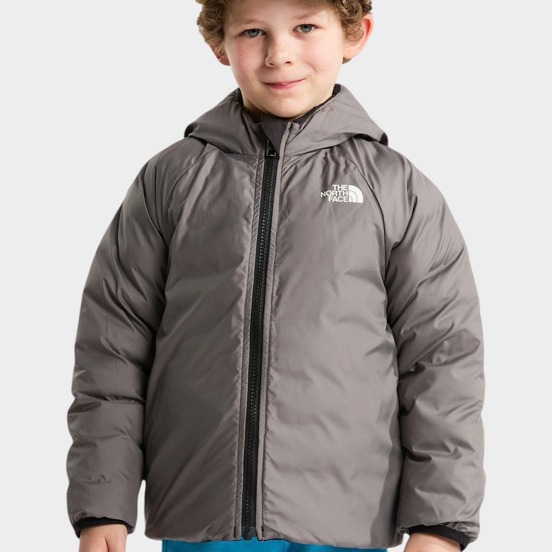 Bambino che indossa una giacca imbottita grigia con cappuccio Follower SRL The North Face e cappellino color oliva