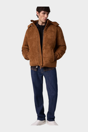 Modello indossa giacca imbottita marrone in pelle scamosciata GUESS con cappuccio, proposta da Follower SRL