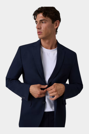 Modello indossa giacca monopetto blu GUESS con texture sottile sopra una t-shirt bianca, stile elegante Follower SRL