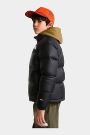 Ragazzo indossa giacca nera 1996 Retro Nuptse Follower SRL con cappuccio color oliva e cappellino arancione