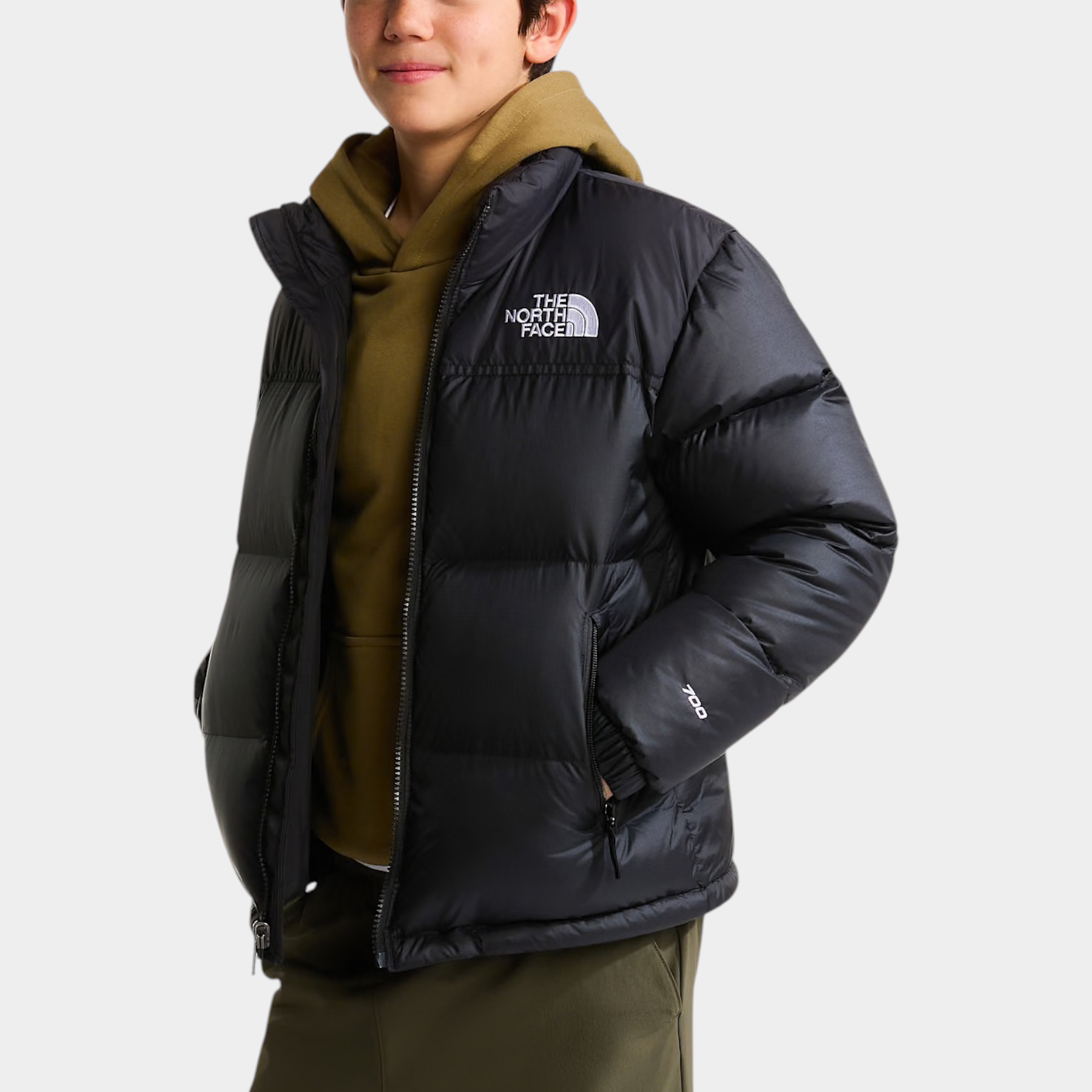 Ragazzo indossa giacca nera 1996 Retro Nuptse Follower SRL con cappellino arancione e felpa verde oliva