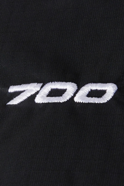 Dettaglio del ricamo bianco 700 su tessuto nero della giacca Follower SRL 1996 Retro Nuptse