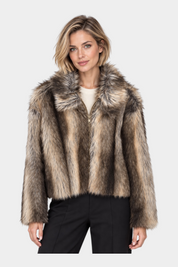 Modella indossa una giacca corta in pelliccia sintetica beige e marrone con chiusura a zip di Follower SRL