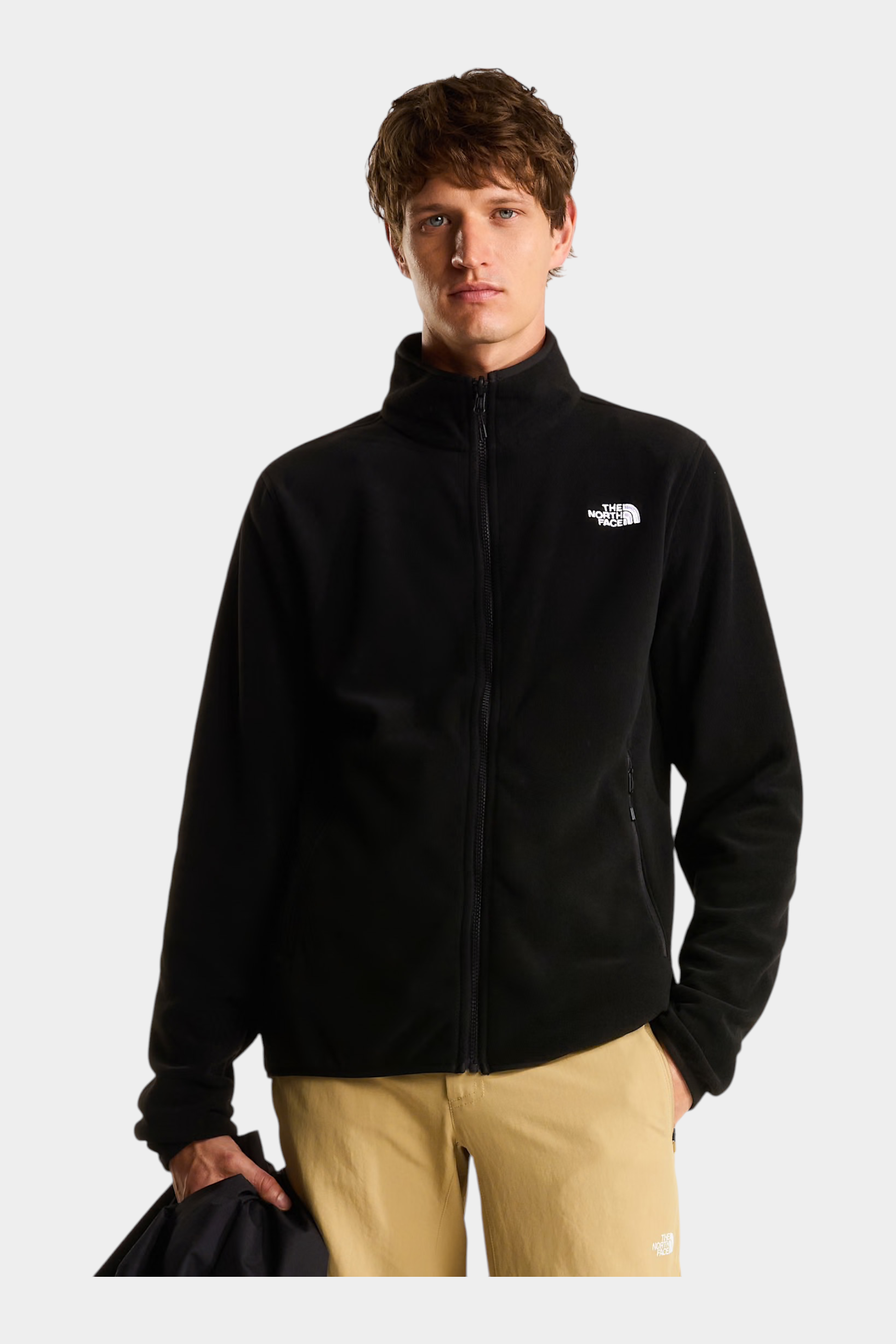 Modello indossa giacca in pile nera Follower SRL con zip integrale e logo The North Face bianco sul petto