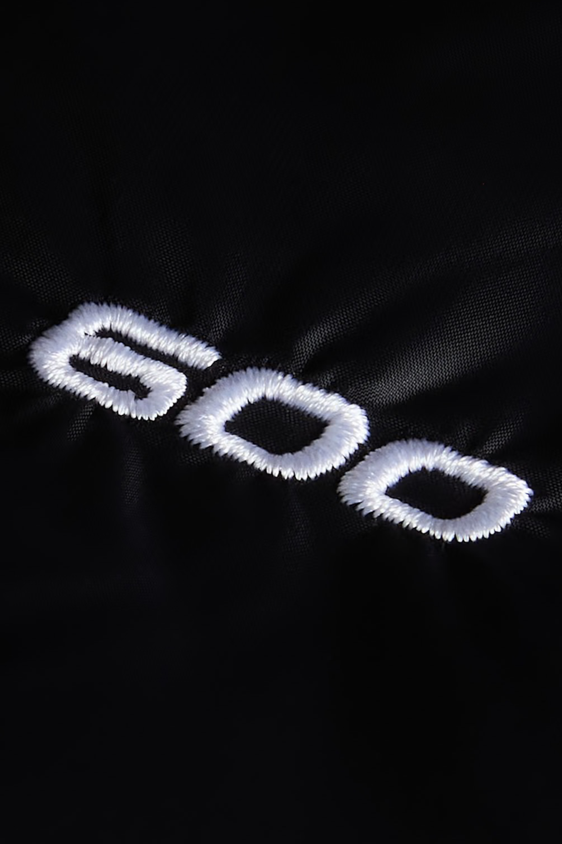 Dettaglio ricamo bianco 600 su tessuto tecnico nero della giacca Follower SRL The North Face