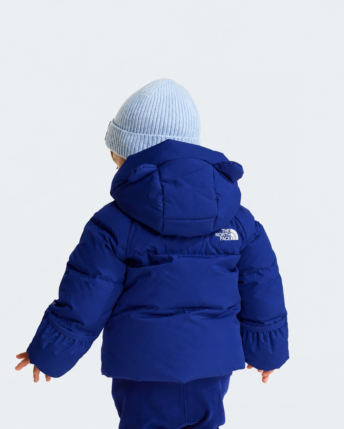 Giacca in piumino blu Follower SRL con cappuccio e logo The North Face vista posteriore su bambino con berretto