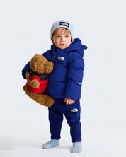 Bambino che indossa giacca in piumino blu THE NORTH FACE con fodera in pile e berretto Follower SRL