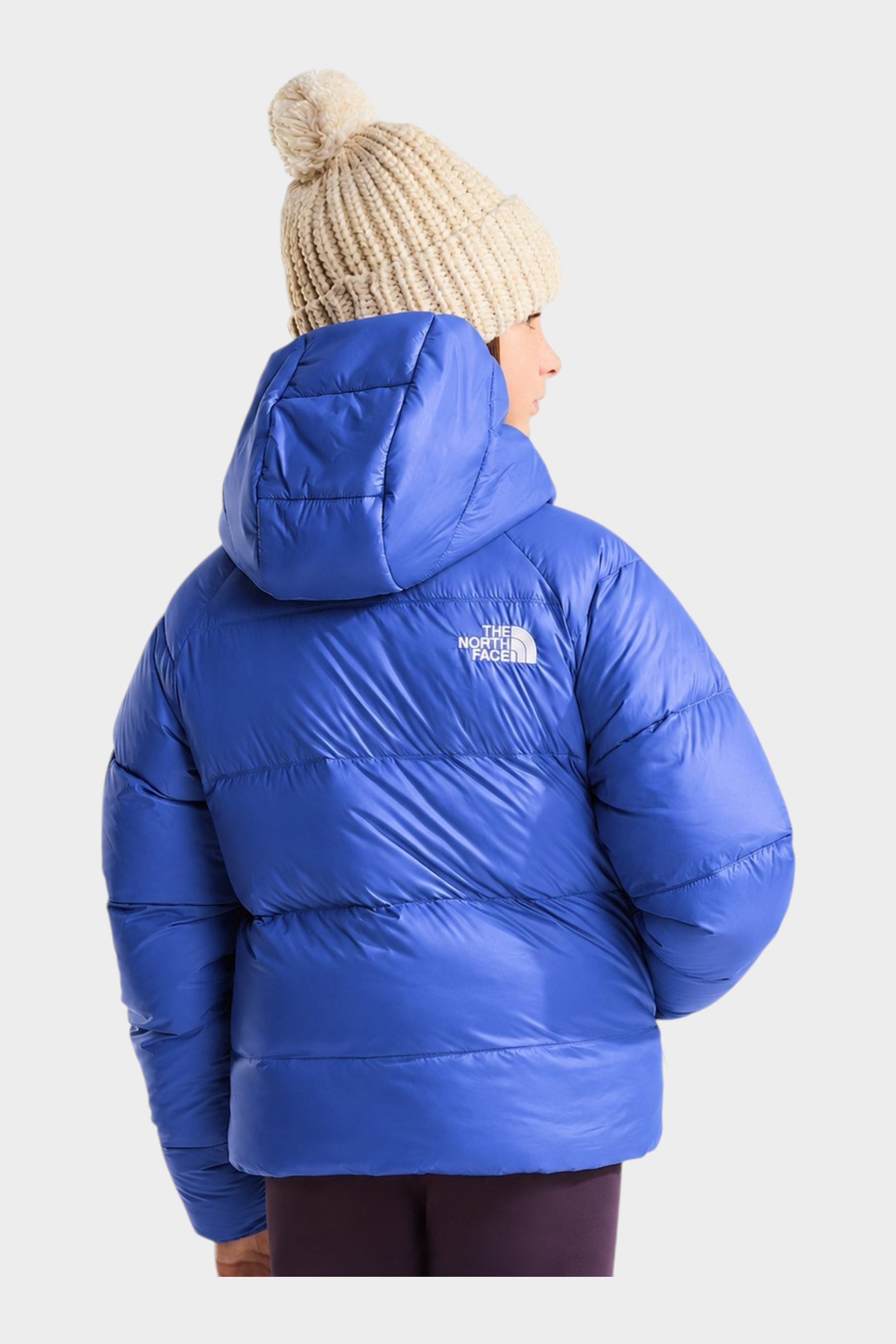 Modella indossa giacca in piumino blu con cappuccio The North Face Hydrenalite e berretto beige Follower SRL