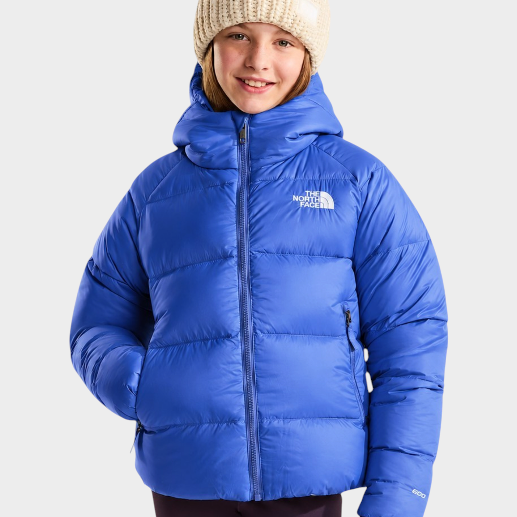 Ragazza che indossa una giacca in piumino blu con cappuccio Follower SRL The North Face e un berretto di lana beige