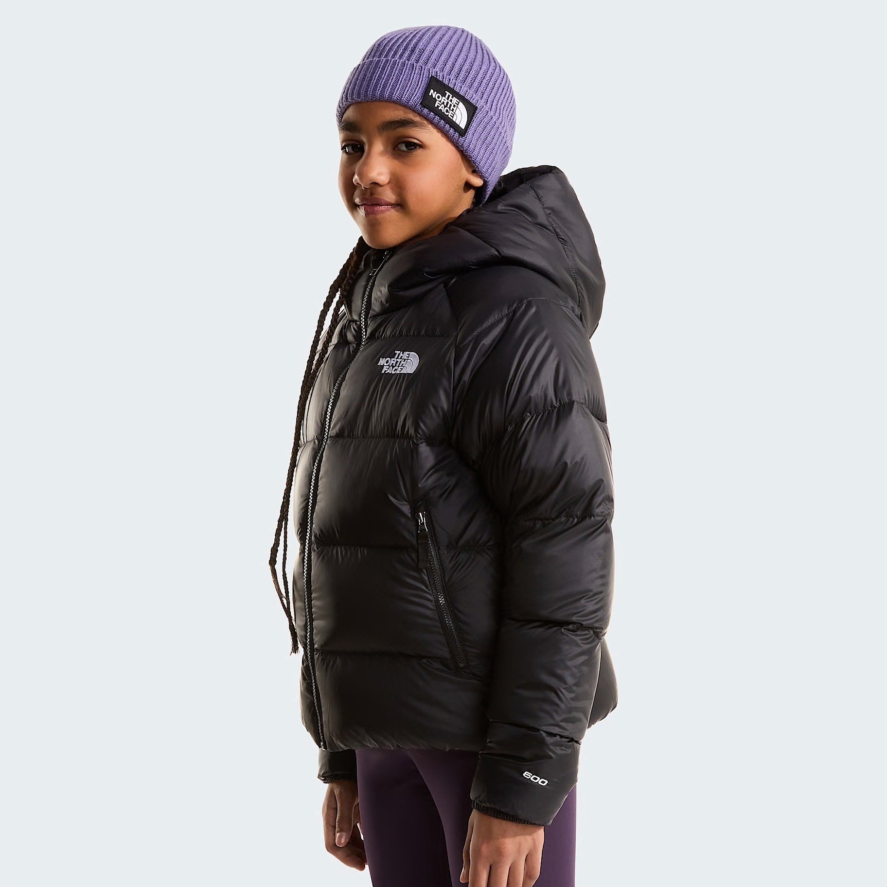 Ragazza indossa giacca in piumino nera con cappuccio Follower SRL Hydrenalite The North Face e berretto viola