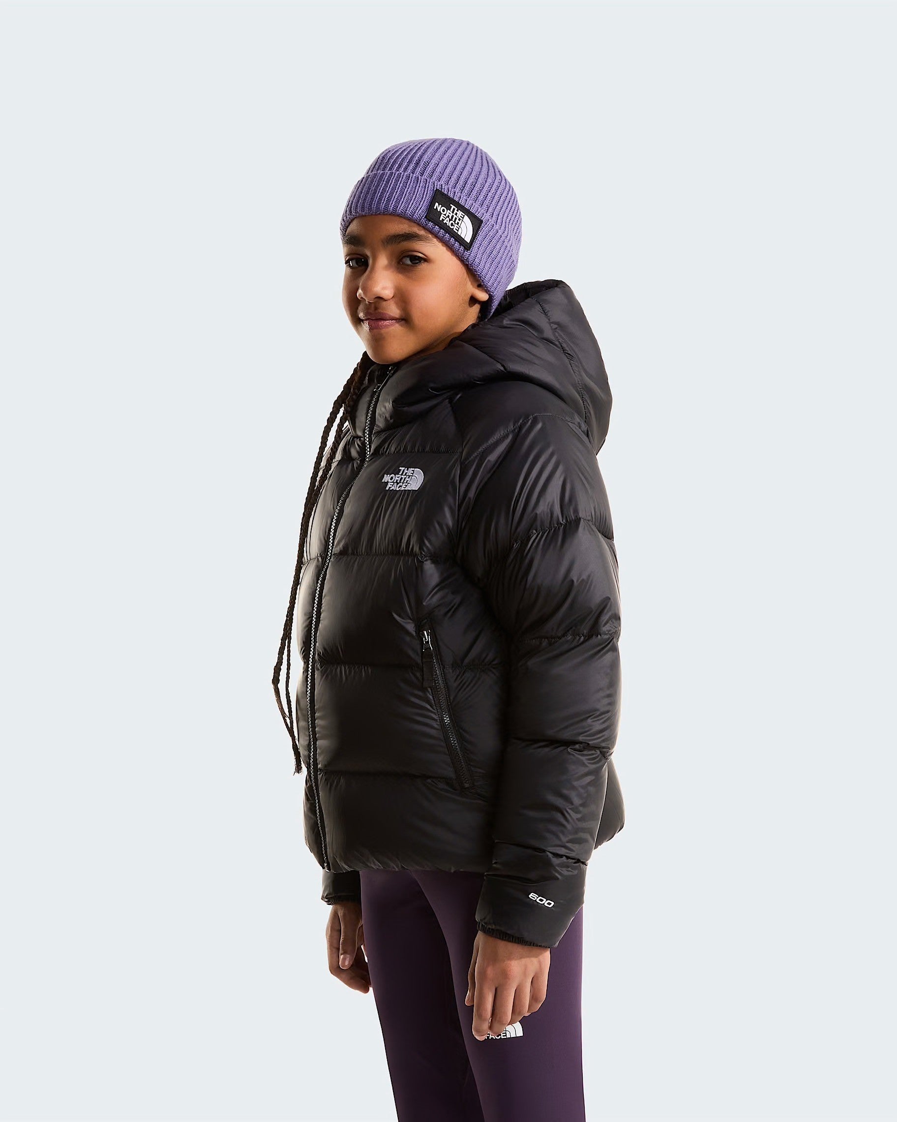 Ragazza indossa giacca in piumino nera con cappuccio Follower SRL Hydrenalite The North Face e berretto viola