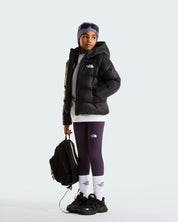 Modella indossa giacca in piumino nera con cappuccio Follower SRL Hydrenalite, leggings viola e zaino nero.