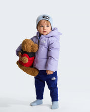 Bambino con giacca in piumino viola The North Face e berretto azzurro, proposta da Follower SRL