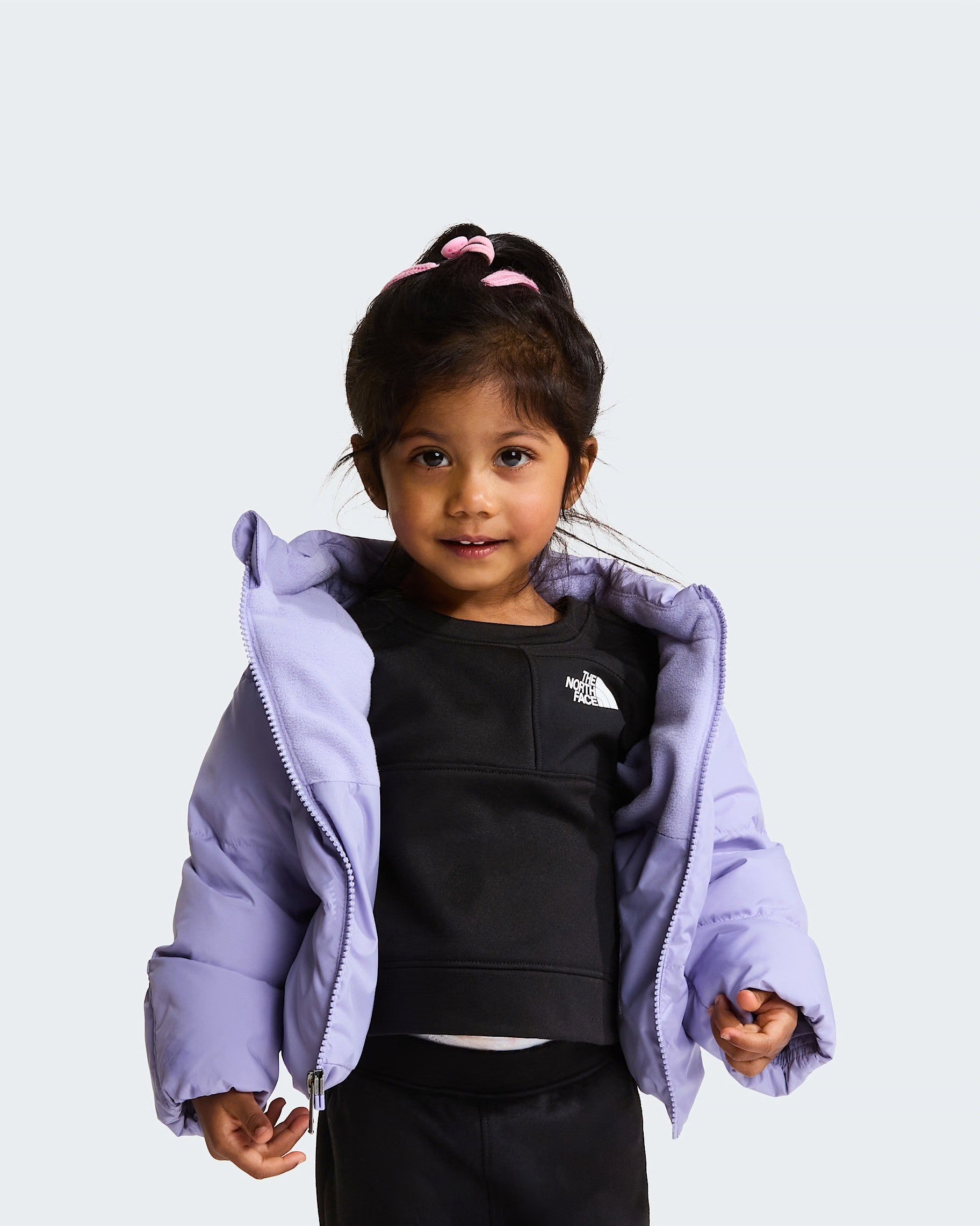 Bambina che indossa una giacca in piumino viola con fodera in pile di Follower SRL e The North Face