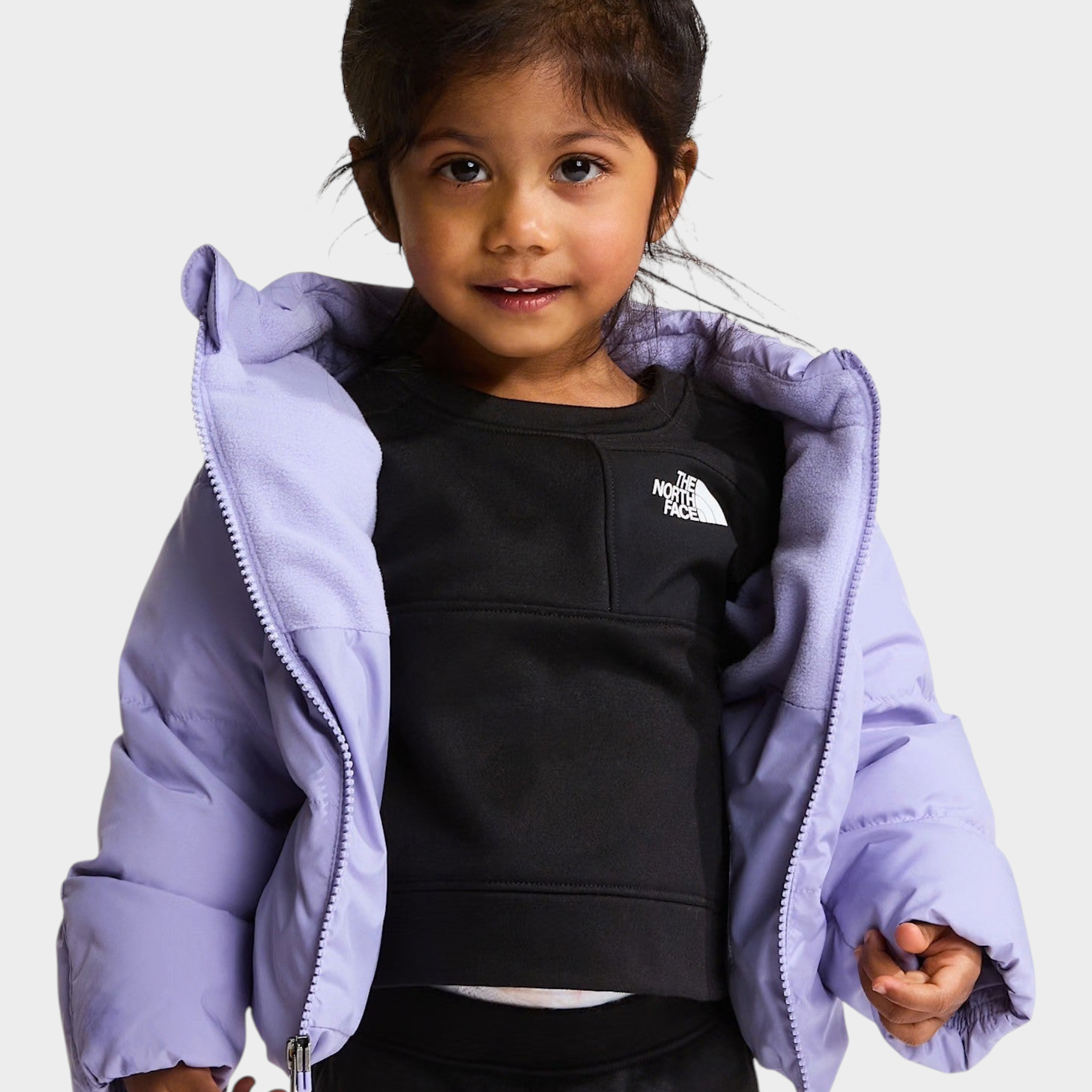 Bambina che indossa una giacca in piumino viola con fodera in pile di Follower SRL e The North Face