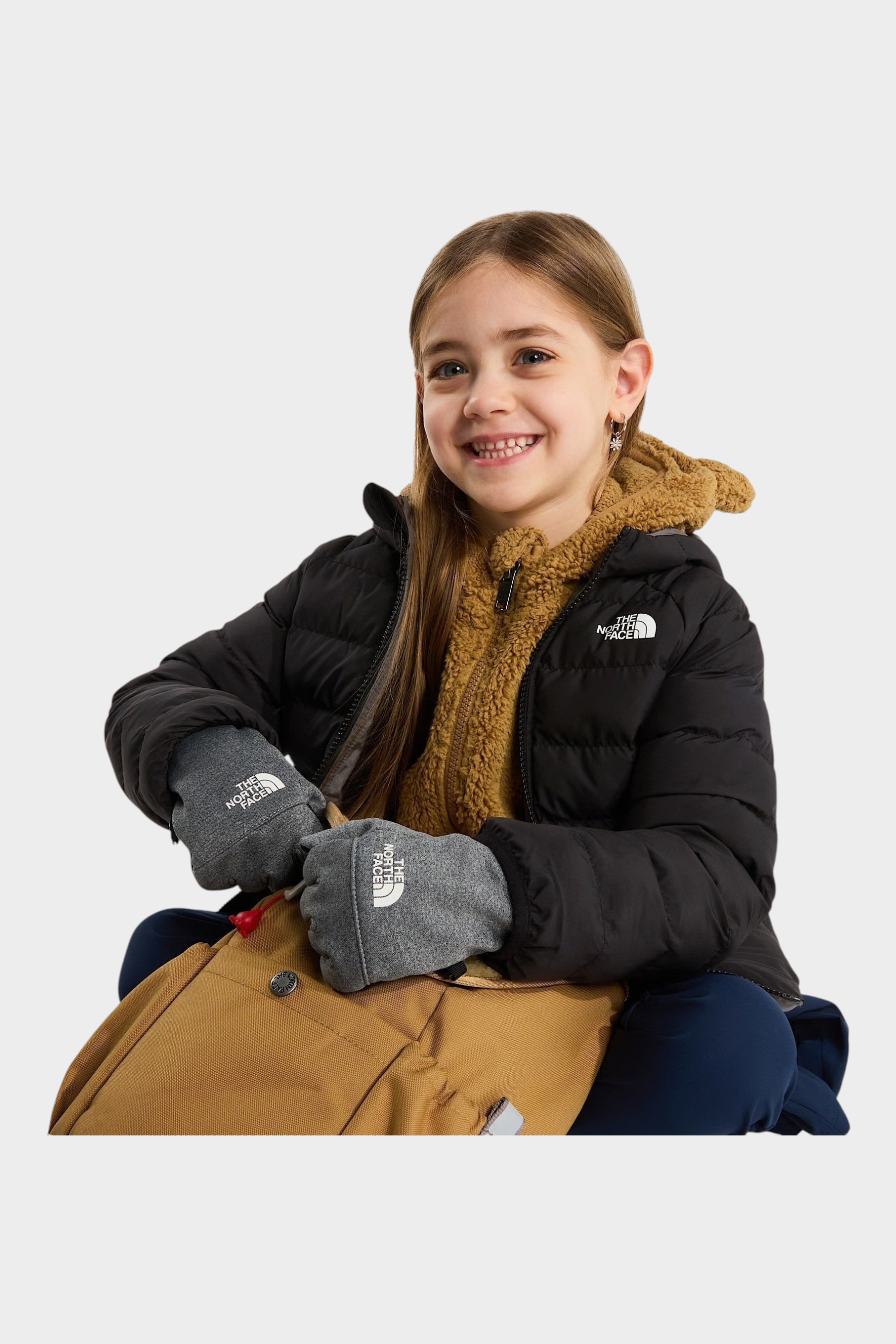 Bambina che indossa una giacca reversibile imbottita nera con cappuccio Follower SRL e guanti grigi
