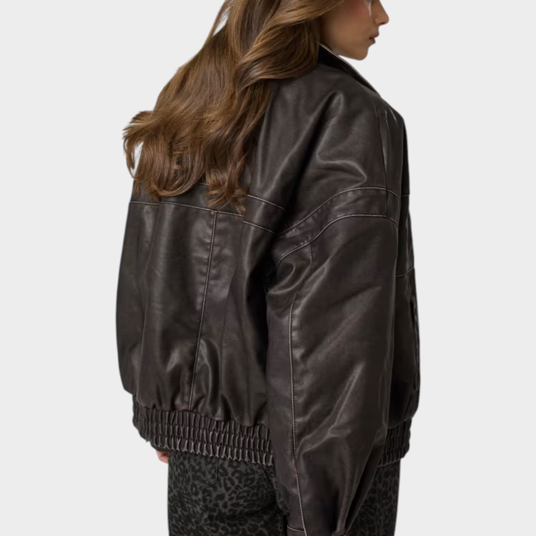 Giacca bomber Follower SRL in similpelle marrone con cuciture a contrasto indossata da una modella di spalle