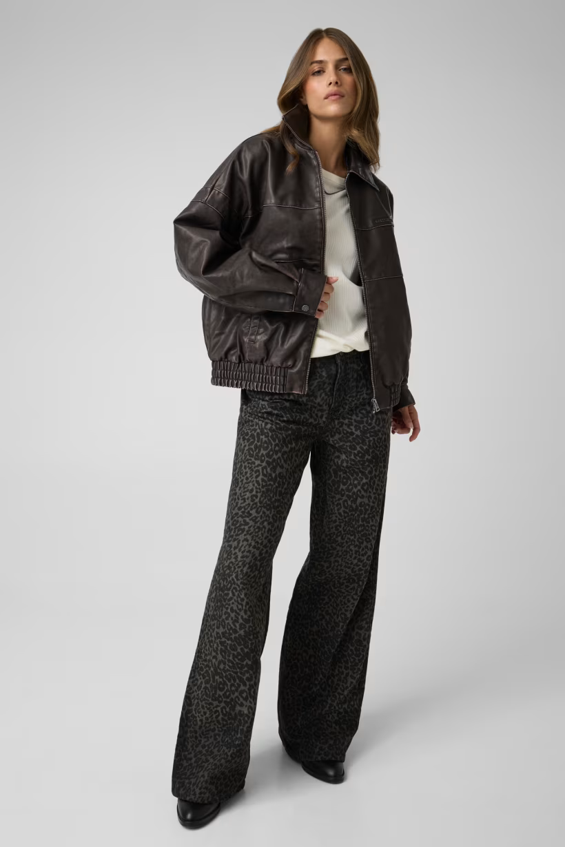 Modella indossa giacca bomber in similpelle marrone GUESS di Follower SRL con orlo elasticizzato e colletto classico