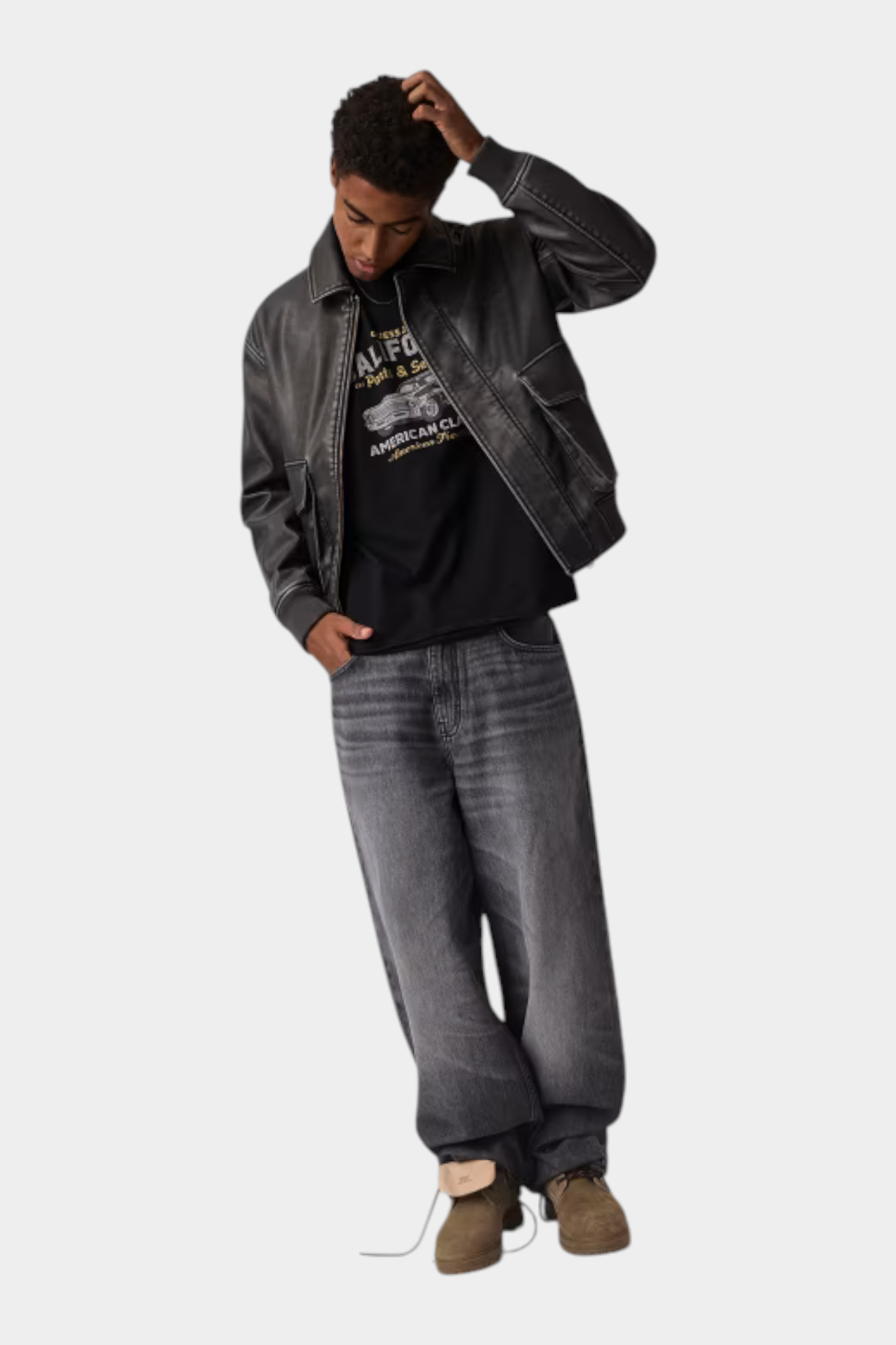 Modello indossa giacca in similpelle nera GUESS con cuciture a contrasto, proposta da Follower SRL