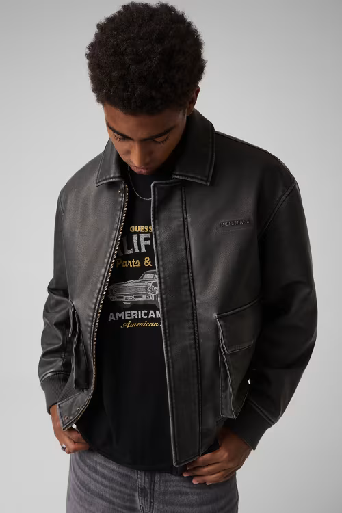 Giacca in similpelle nera da uomo GUESS indossata da un modello, stile bomber con tasche frontali, Follower SRL