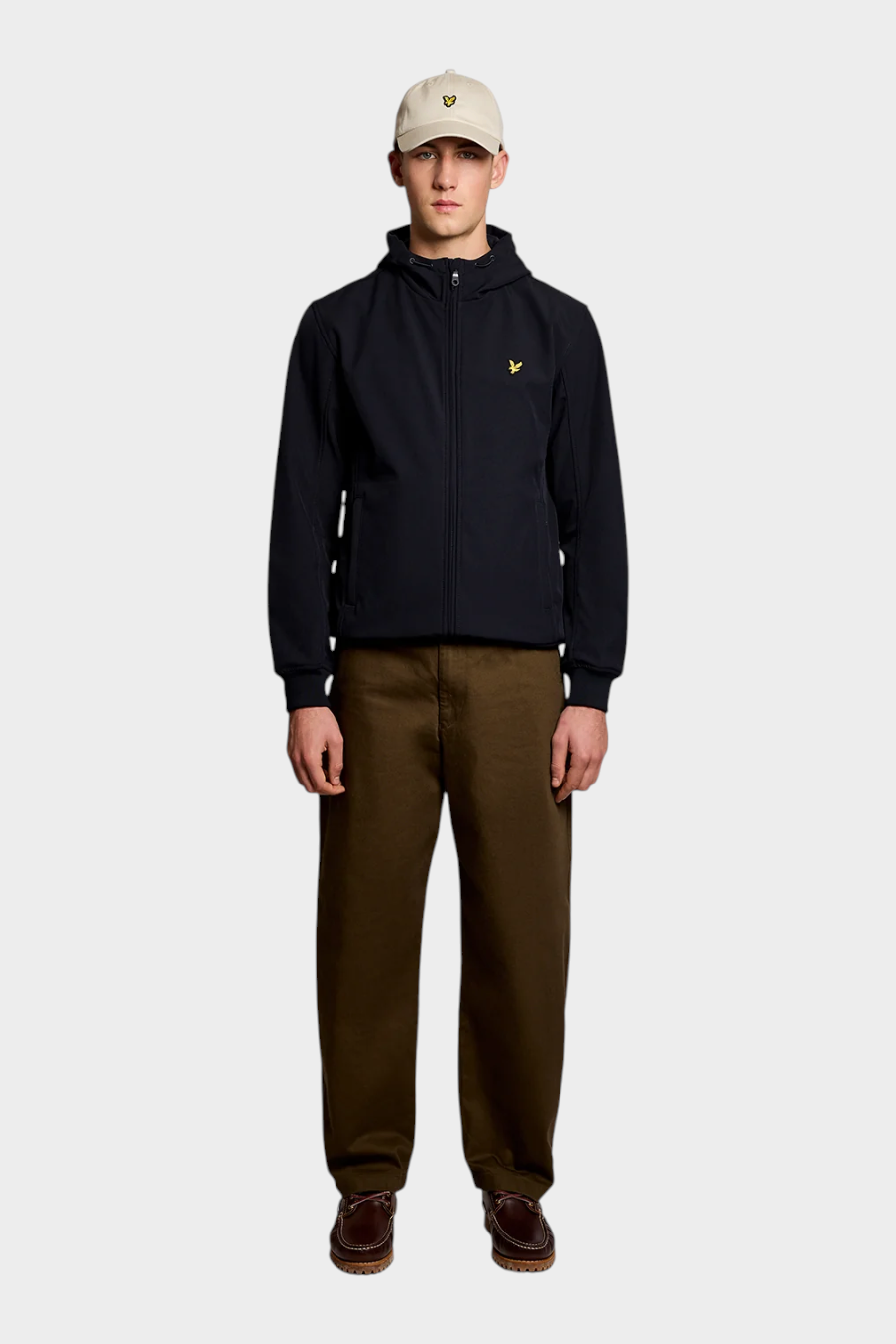 Modello indossa giacca softshell blu LYLE & SCOTT con cappuccio e logo giallo, proposta da Follower SRL