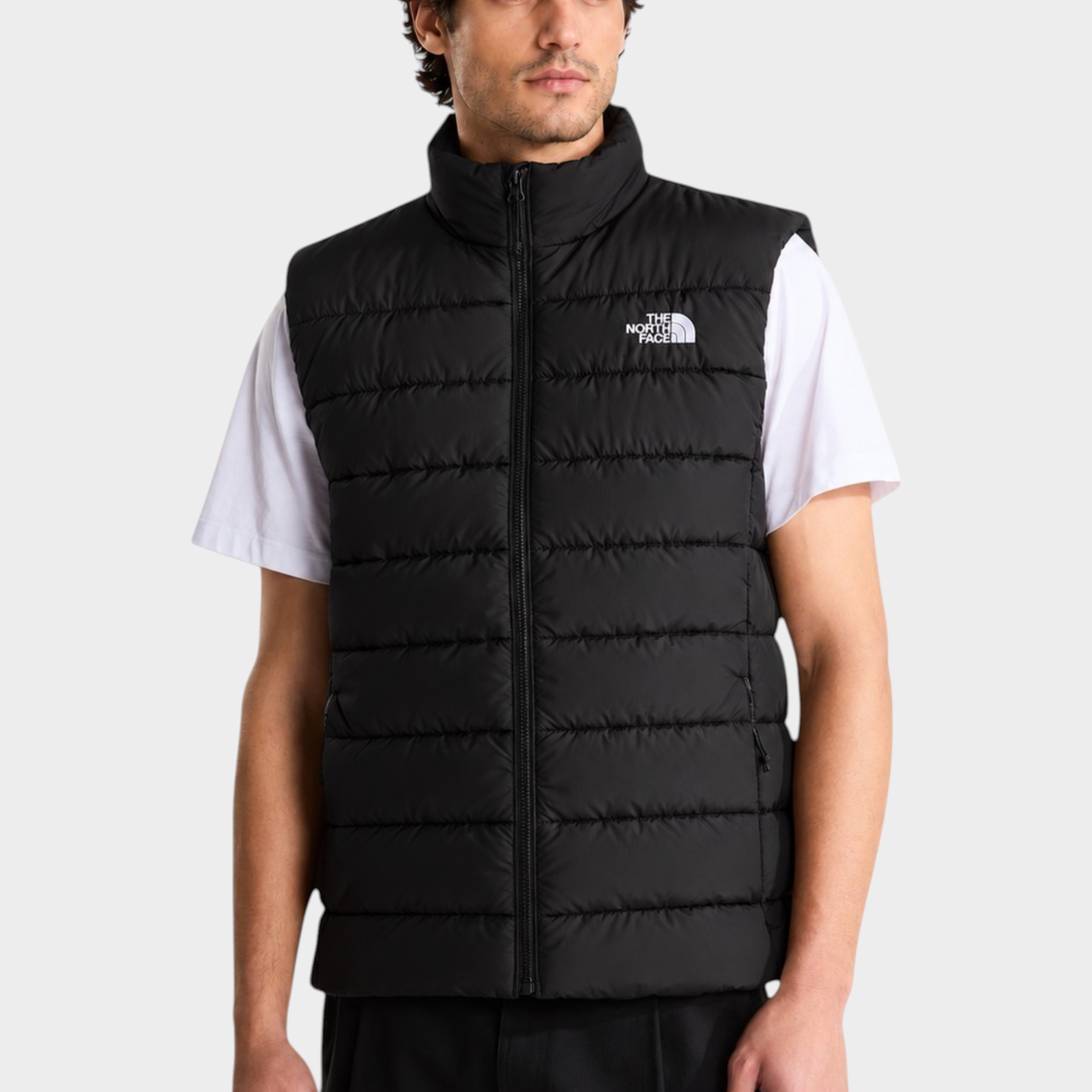 Modello indossa gilet imbottito nero Follower SRL con tecnologia WindWall e logo The North Face sul petto