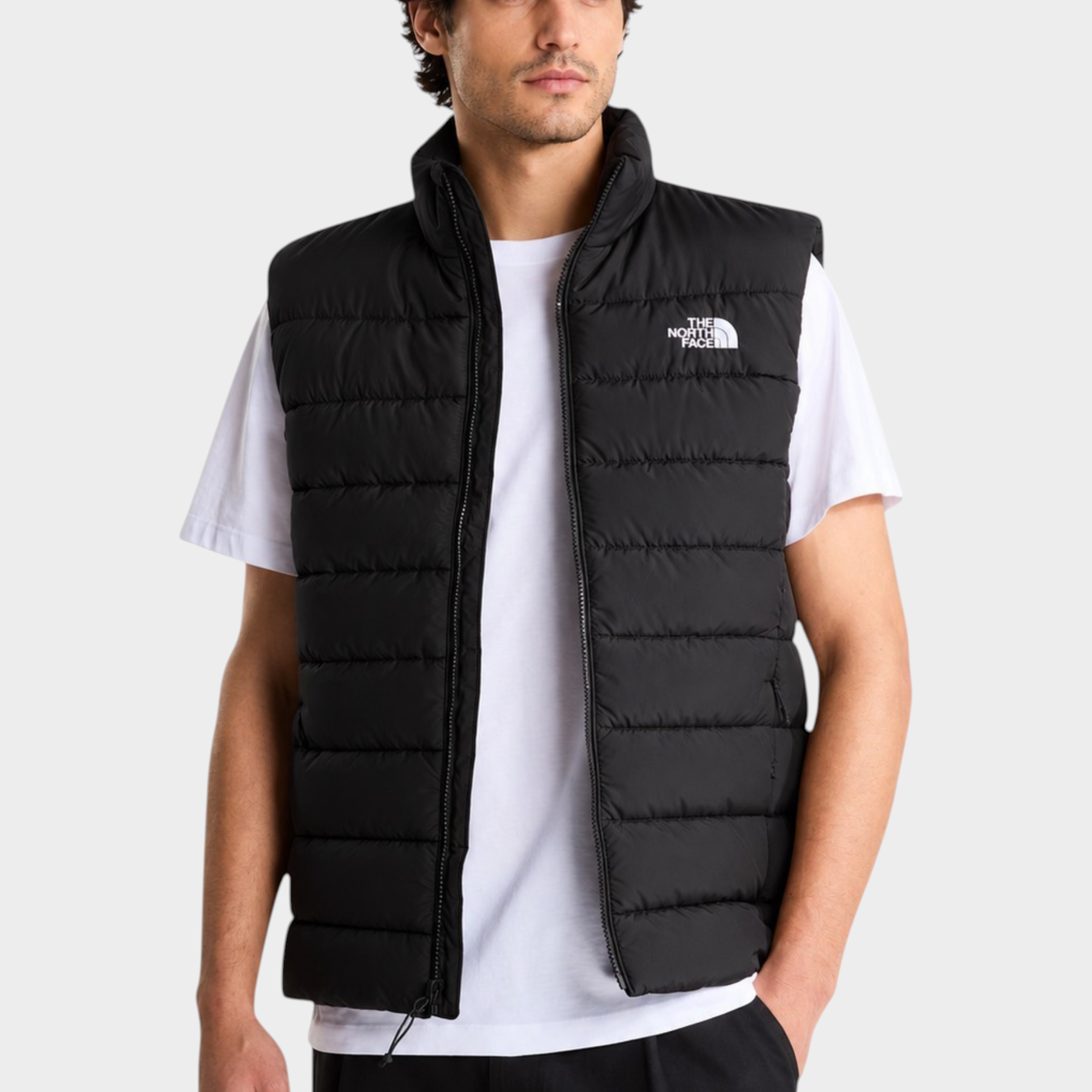 Modello indossa gilet imbottito nero Follower SRL The North Face con tecnologia WindWall e logo bianco sul petto