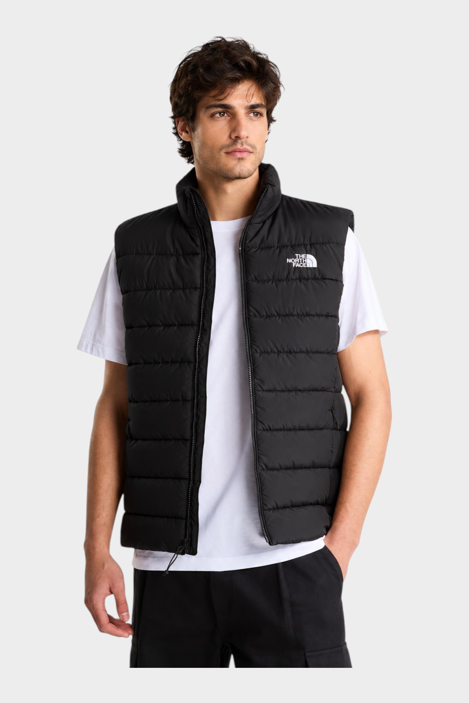 Modello indossa gilet imbottito nero Follower SRL The North Face con tecnologia WindWall e logo bianco sul petto