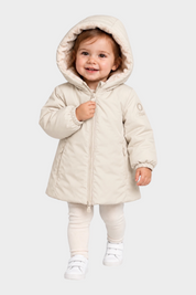 Bambina che indossa il giubbino Aurelia in velour color avorio di Follower SRL con cappuccio e chiusura a zip