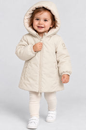 Bambina che indossa il giubbino Aurelia in velour color avorio di Follower SRL con cappuccio e chiusura a zip