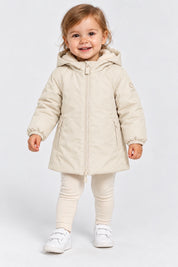 Bambina che indossa il giubbino Aurelia in velluto color avorio di Follower SRL con cappuccio e chiusura a zip
