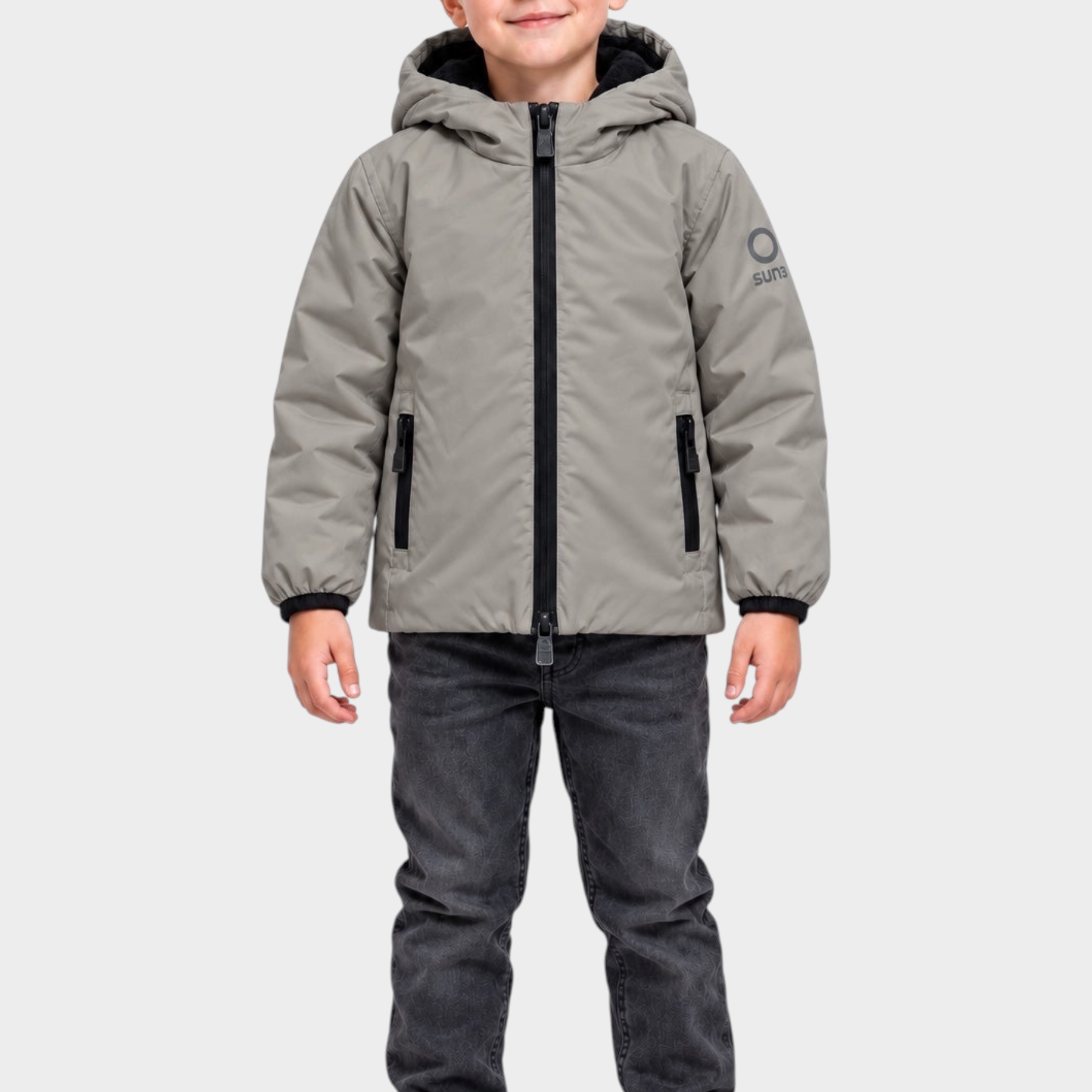Bambino che indossa un giubbino grigio con cappuccio SUNS BOARDS di Follower SRL, con zip nera e logo sulla manica