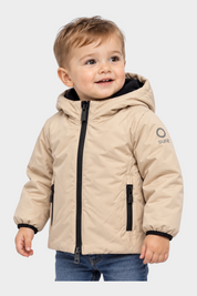 Bambino che indossa un giubbino beige Follower SRL con cappuccio, zip nera e logo SUNS BOARDS sulla manica