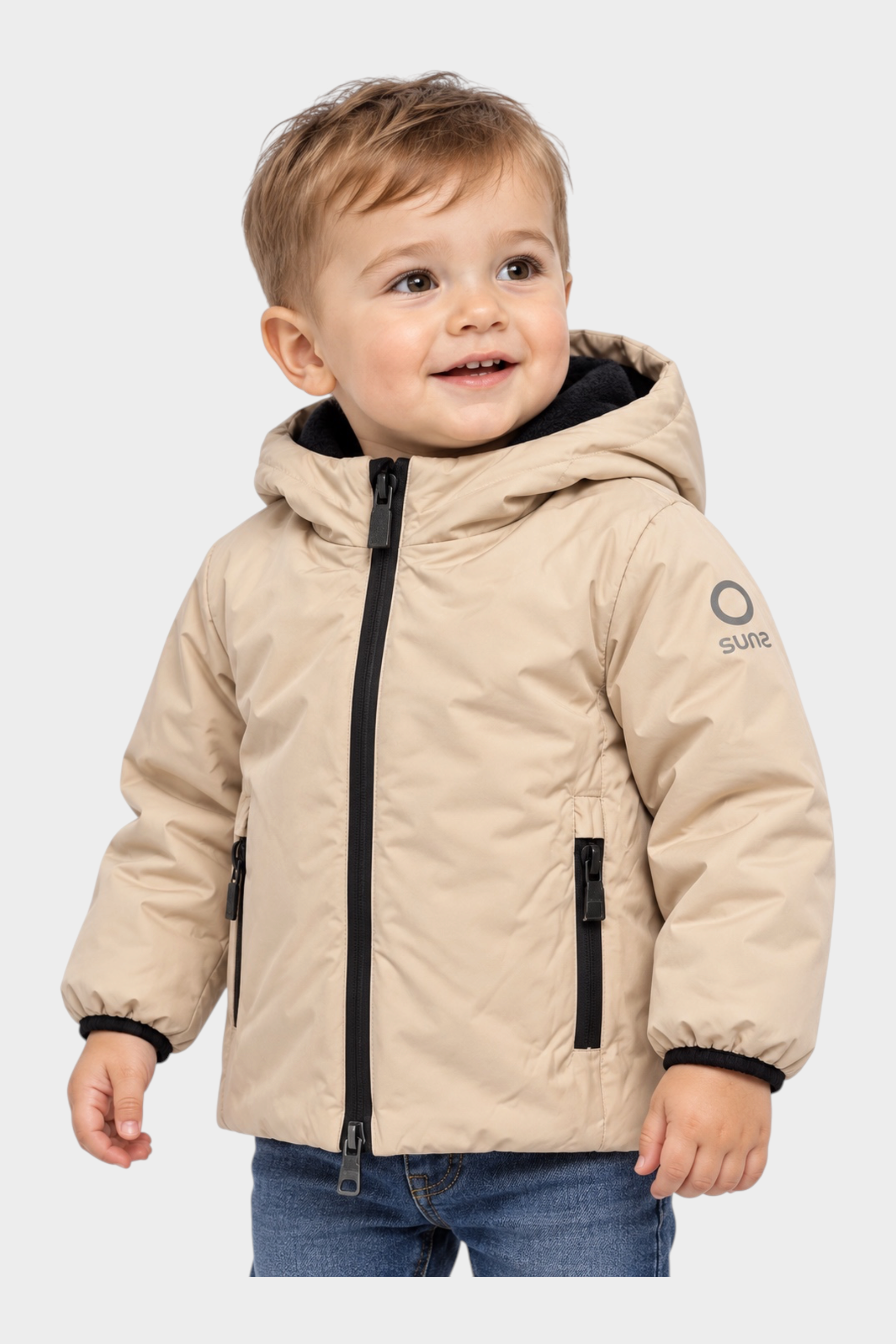 Bambino che indossa un giubbino beige Follower SRL con cappuccio, zip nera e logo SUNS BOARDS sulla manica