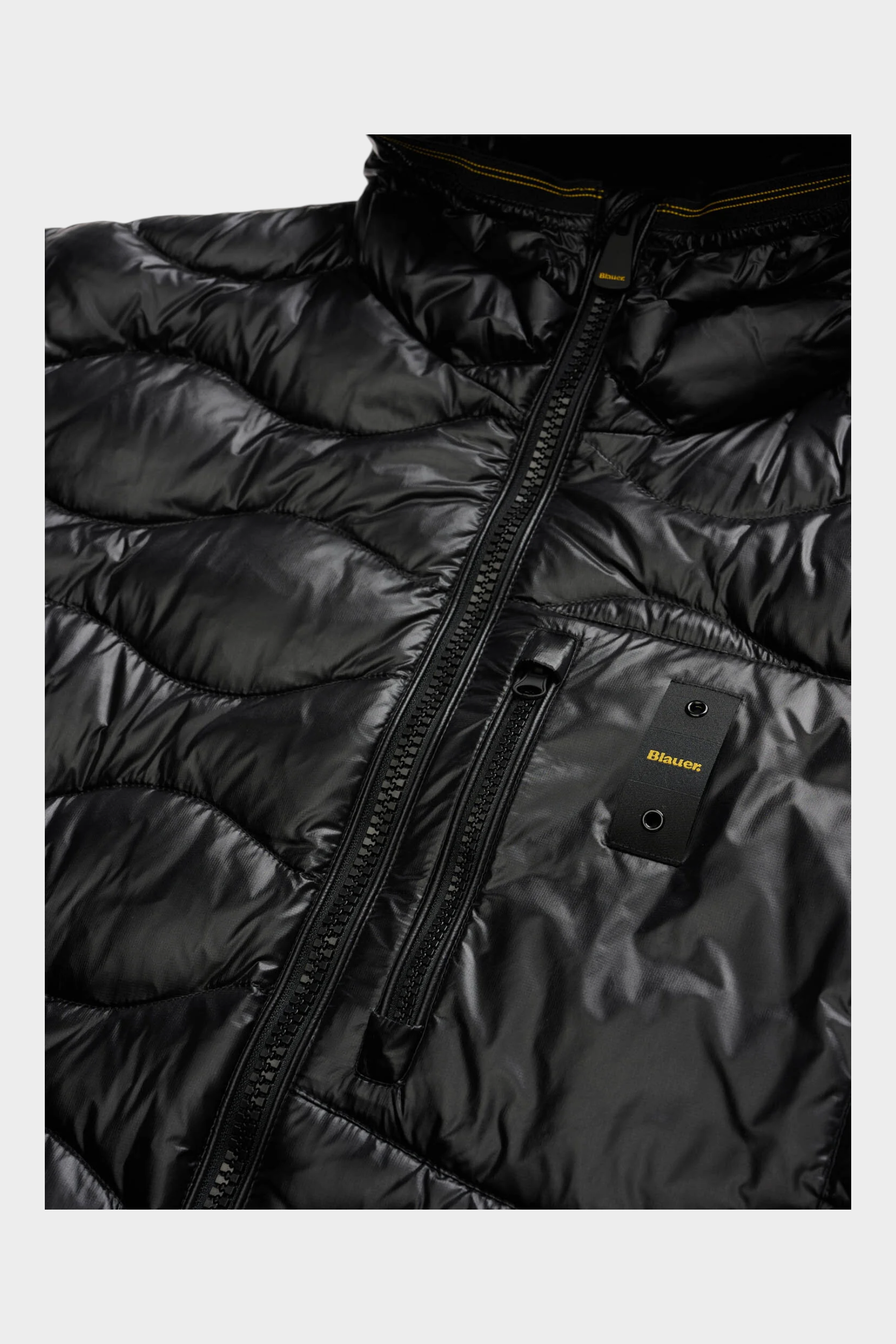 Dettaglio del giubbino nero Follower SRL Blauer con trapuntatura a onde, zip frontale e patch logo sul petto