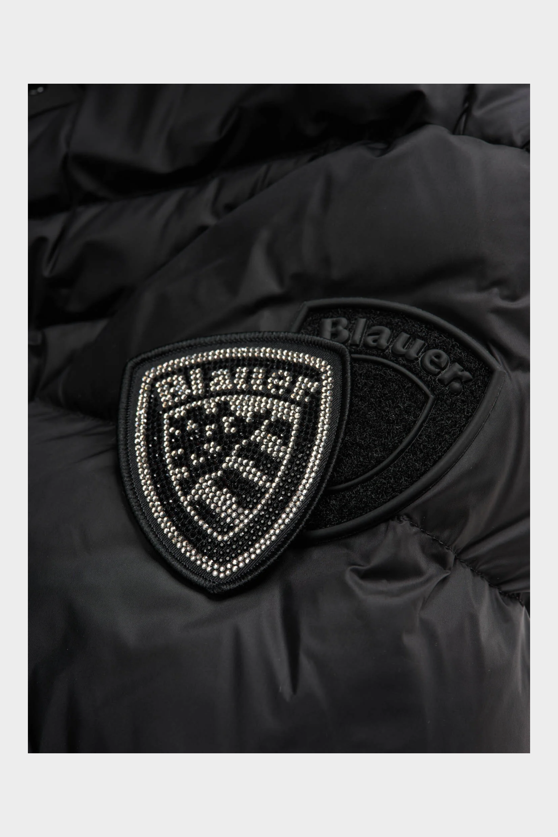 Dettaglio del logo Blauer con strass su giubbino nero trapuntato Follower SRL