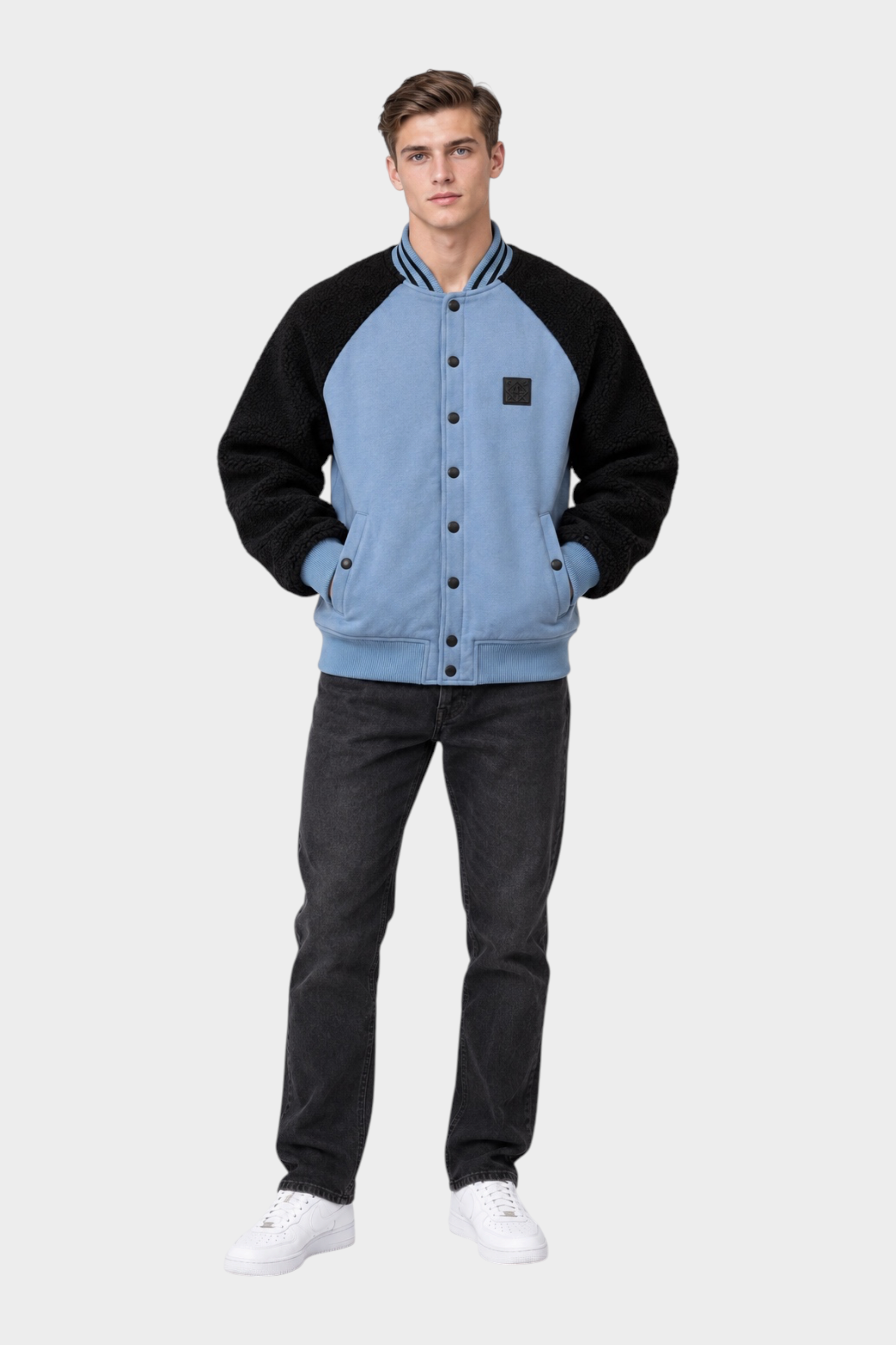 Modello indossa giubbino bomber Follower SRL azzurro e nero con maniche in tessuto teddy e chiusura a bottoni