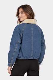 Giubbino bomber in denim blu GUESS con colletto in pelliccia sintetica indossato da una modella, Follower SRL